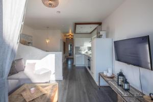 ein Wohnzimmer mit einem großen TV und einem Sofa in der Unterkunft Lodge in Westerland - Beachtime in Westerland