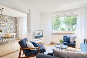 sala de estar con sofá, sillas y TV en _Kleine Pause_ en Riepsdorf