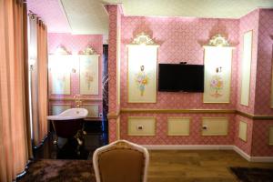 a room with a pink wall with three windows at Golden Ring Resort in Tirana