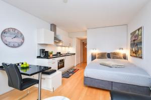 een slaapkamer met een bed, een bureau en een klok bij Appartement 718 in Timmendorfer Strand