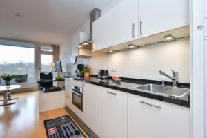 uma cozinha com armários brancos e um lavatório em Appartement 718 em Timmendorfer Strand