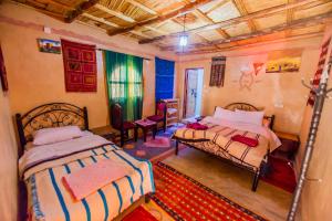 1 dormitorio con 2 camas en una habitación en Dar tiwira, en Aït Baha