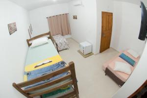 ein kleines Zimmer mit einem Etagenbett und ein Schlafzimmer mit einer Tür in der Unterkunft Pousada Casa Verde in Penha