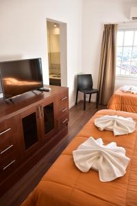 a hotel room with two beds and a flat screen tv at Alamo Hotel in Villa Carlos Paz