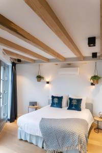 a bedroom with a large white bed with blue pillows at Canal view suite in Amsterdam