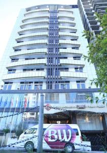 a bus parked in front of a tall building at Best Western Plus Pearl Addis in Addis Ababa