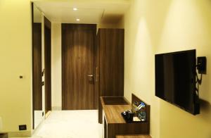 a room with a television on a wall with a door at ECONEST HOTEL in Tarapith