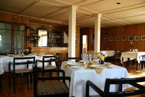 a restaurant with tables and chairs with white tablecloths at Hotel Unicornio Azul in Castro
