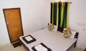 a room with a couch with a green curtain at Baywatch Beach Resort in Alleppey