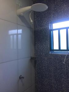 ducha con puerta de cristal y ventana en el baño en Farol da Barra Seca Ubatuba, en Ubatuba