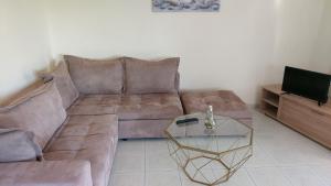 un soggiorno con divano marrone e tavolo in vetro di Dolphin 2 a Artemida