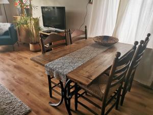 a wooden dining room table with chairs and a television at B&B In De Backerije 2 in Zuidwolde