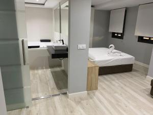 a bathroom with a sink and a bed in a room at Apartamentos Las 7 Esencias in Linares +30 photos