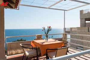 una mesa y sillas en un balcón con vistas al océano en Apartments Mare, en Dubrovnik