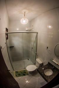 uma casa de banho com um chuveiro, um WC e um lavatório. em Chalés Pipa em Pipa