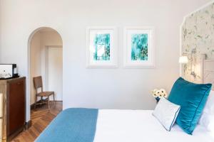 a bedroom with a bed, chair and a window at Terme di Saturnia Natural Spa & Golf Resort - The Leading Hotels of the World in Saturnia