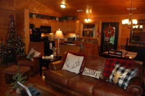 a living room with a couch and a christmas tree at His Promises Cabin in Pigeon Forge