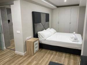 a small bedroom with a bed and a walk in shower at Apartamentos Las 7 Esencias in Linares