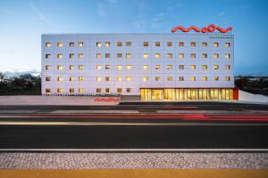 un bâtiment blanc avec un panneau sur son côté dans l'établissement Moov Hotel Oeiras, à Oeiras