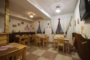 a restaurant with wooden tables and chairs in a room at Na Gorbi in Slavske