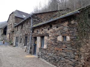 ein altes Steingebäude mit einem Hund daneben. in der Unterkunft Le val de coussane in Coubisou