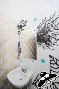 a bathroom with a black and white striped wall at Straw Hat Hostel & Rooftop Bar in Tulum