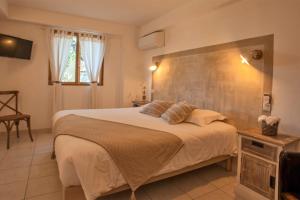 ein Schlafzimmer mit einem großen Bett in einem Zimmer in der Unterkunft location de vacances Olivier jardin privatif et piscine chauffée partagée in Calvi