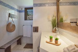 bagno con lavandino e specchio di location de vacances Olivier jardin privatif et piscine chauffée partagée a Calvi