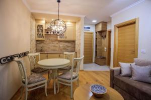 a kitchen and living room with a table and a couch at AS apartman in Zlatibor
