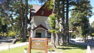 un cartel frente a una casa con árboles en Hotel Colina São Francisco, en Gramado