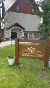 a sign in the grass in front of a building at Hotel Colina São Francisco in Gramado