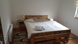 een slaapkamer met een houten bed met 2 kussens erop bij Aska Apartments Vrnjacka Banja in Vrnjačka Banja