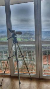 a camera on a tripod in front of a window at Tsarevets panoramic apartments Veliko Tarnovo in Veliko Tŭrnovo