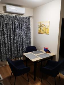 a table and chairs in a room with a curtain at Ágnes Apartman in Kaposvár
