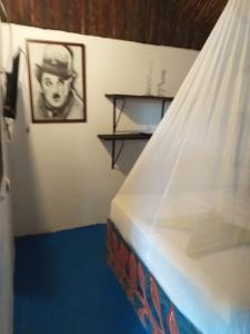a bedroom with a bed and a picture of a man at Hostel Cattleya in Palomino