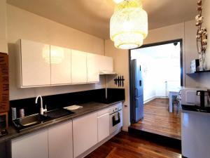 cocina con armarios blancos, fregadero y ventana en Appartement coeur centre-ville cosy et chaleureux rue Carnot en Châlons-en-Champagne