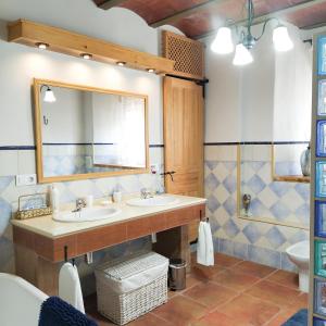La salle de bains est pourvue de 2 lavabos et d'un miroir. dans l'établissement Alojamiento Rural Medios Panes, à Puerto Alto