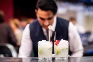 a man sitting at a table with two cocktails at ibis Brussels Centre Chatelain in Brussels