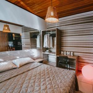 a bedroom with a large bed and a desk at Bosque da Praia Chalé 5 in Pipa