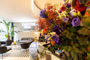 a lobby with a bunch of flowers on a table at ibis Brussels Centre Chatelain in Brussels