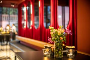 a vase of flowers on a table with a train at ibis Brussels Centre Chatelain in Brussels