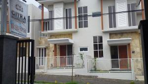 バトゥにあるCitra Homestayのバルコニーと柵付きの白い建物