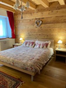 a bedroom with a bed with wooden walls at Casa Romeo in San Vito di Cadore