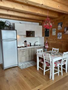 a kitchen with a table and a white refrigerator at Casa Romeo in San Vito di Cadore