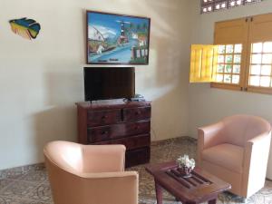 a living room with two chairs and a flat screen tv at Casa com 4 quartos em condomínio fechado in Tamandaré