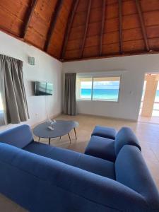 a living room with a blue couch and a table at Caleta Tankah in Tulum