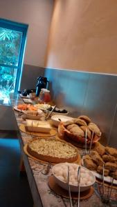 a table with pies and other food on it at Lothlorien Vale do Capão in Vale do Capao