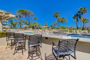 a group of chairs sitting around a bar by a pool at Luxury 2 BR 2 BA Oceanfront Condo King Bed 2 Twins Bikes & Beach Gear included in Hilton Head Island