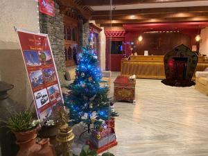 
a living room filled with christmas decorations and a fire place at Three Jewels Boutique Hotel in Pokhara
