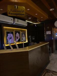 een balie in een restaurant met foto's van mensen bij Al Fanar Al Alamaya 3- Hay'aa Malakeya entrance in Yanbu